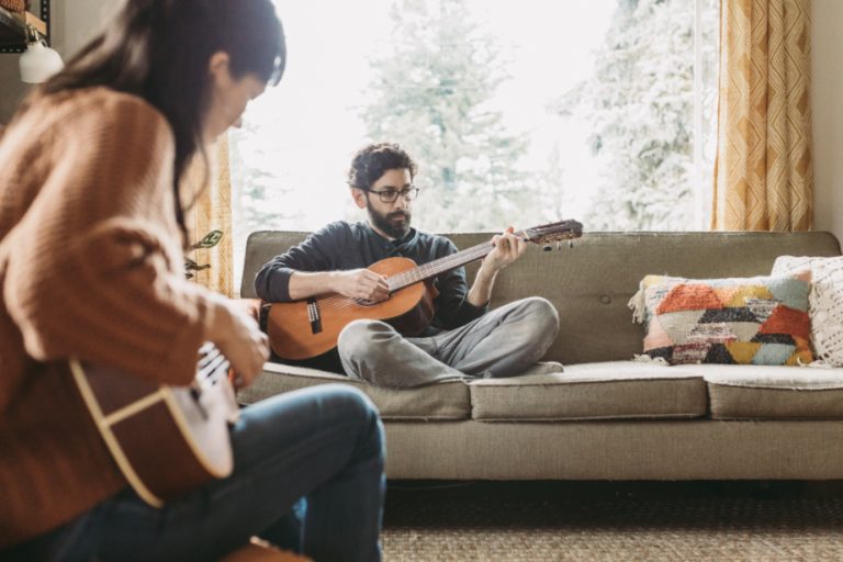 couple playing music on guitar