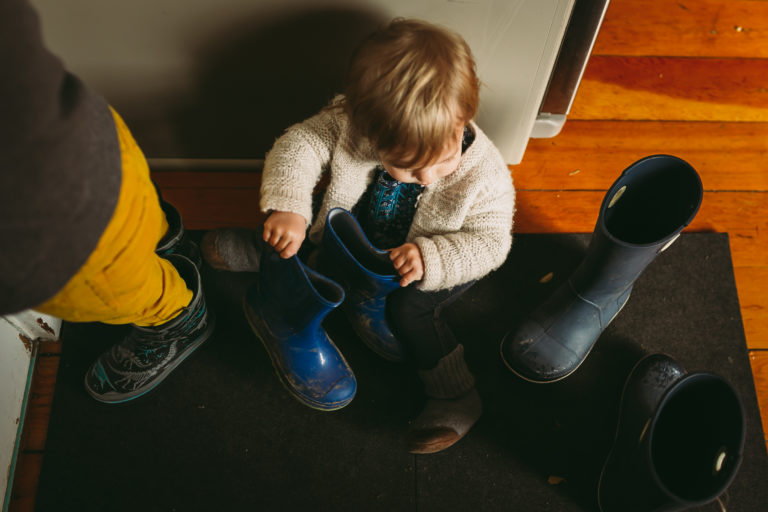 Child playing with winter boots.