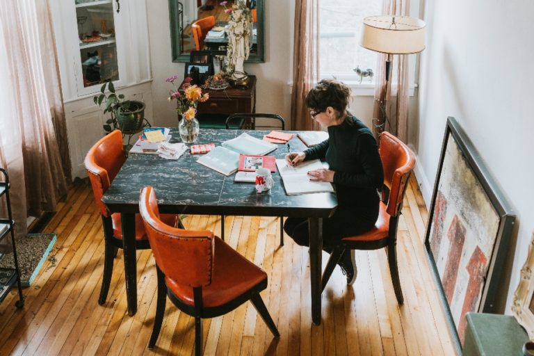 Woman doing work on dining room table